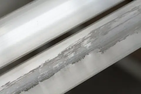 Aluminium nie rdzewieje, ale może ulegać korozji, tworząc biały nalot, jak widać na tych metalowych profilach.
