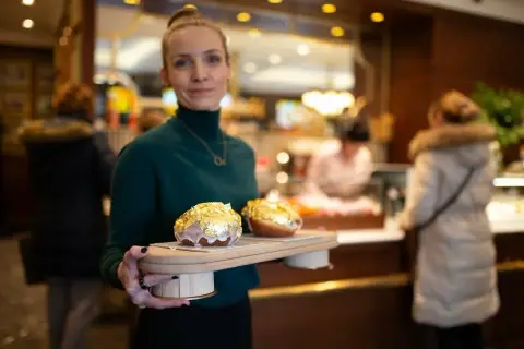 Elegancka piekarnia po francusku prezentuje dwa pączki w płatkach złota.