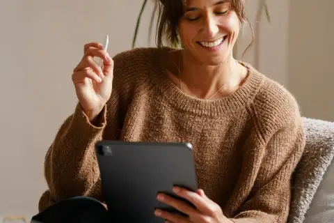 Uśmiechnięta kobieta z rysikiem w dłoni przegląda coś na tablecie. Jaki tablet, taki komfort pracy!