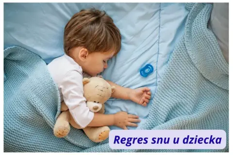Małe dziecko śpi z misiem i smoczkiem. Czasem pojawia się regres snu u dziecka, ale teraz jest spokojnie.
