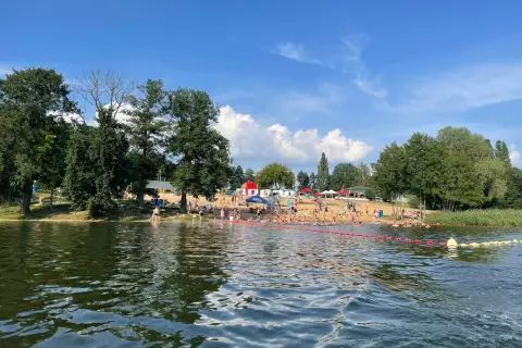 Słoneczny dzień nad jeziorem, pełnym ludzi kąpiących się i opalających. To jedne z fajnych miejsc nad wodą mazowieckie.