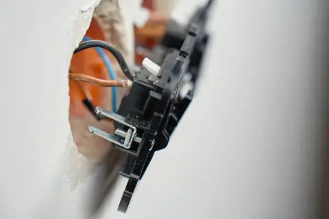 Widok z bliska na instalację elektryczną: widoczne przewody i mechanizm wypustu zasilającego 1 fazowy w trakcie montażu.