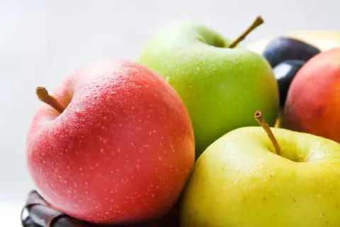 Frische Äpfel in Rot, Grün und Gelb, mit Wassertropfen bedeckt. Sie sind ein gesunder Snack und bieten gute Apfel Nährwerte.
