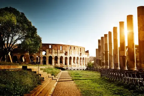 Il Colosseo e le colonne antiche, un'icona tra le 20 cose da vedere a Roma, illuminate dal sole del tramonto.