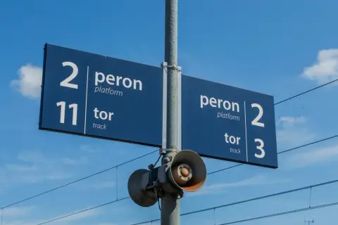 Niebieska tablica informacyjna na dworcu kolejowym wskazuje peron 2, tor 11 oraz peron 2, tor 3.