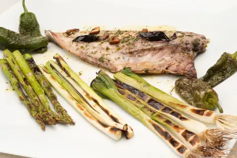 Pescado chicharro a la plancha con espárragos, pimientos de Padrón y cebolletas asadas.