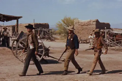 Rio Bravo obsada: John Wayne, Dean Martin i Ricky Nelson idą przez miasteczko.