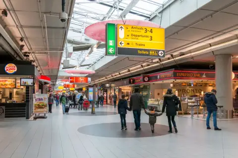 Lotnisko w Amsterdamie: rodzina idzie przez terminal, obok Burger Kinga i sklepów.