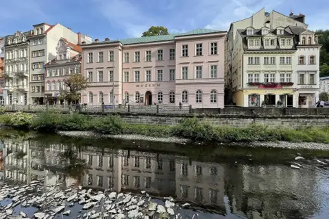 Nad rzeką w Karlowych Warach odbijają się w wodzie zabytkowe kamienice i budynek muzeum.