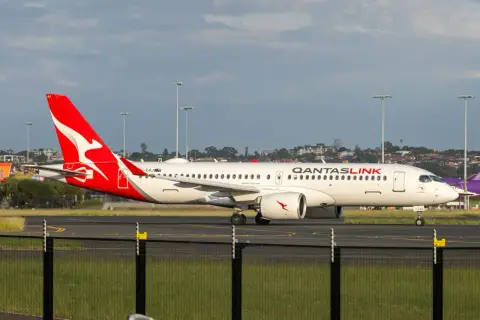 Airbus A321neo QantasLink na płycie lotniska, z charakterystycznym czerwonym ogonem i logo.
