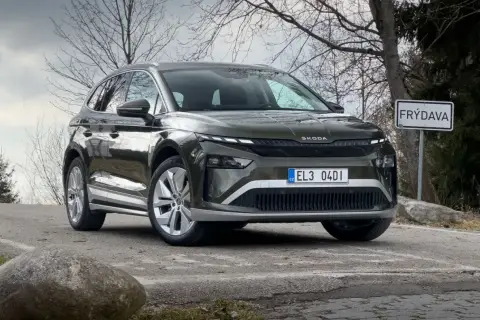 Zielony Skoda Enyaq na drodze, obok znaku "FRÝDAVA". Sprawdź atrakcyjną skoda enyaq cena.