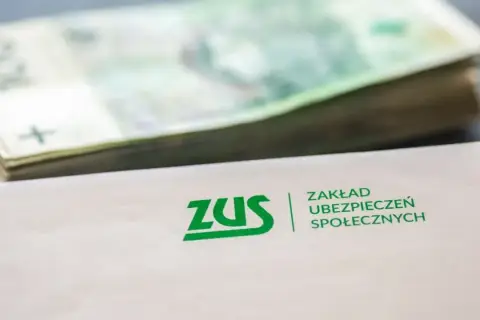 ZUS i stos banknotów. Dokumenty ZUS mogą oznaczać nadzieję na rentę po zmarłym ojcu.