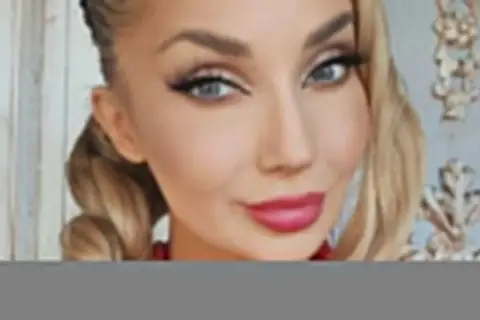 Piękna kobieta, jak ma na imię Cleo, z blond warkoczami i czerwoną koralami.