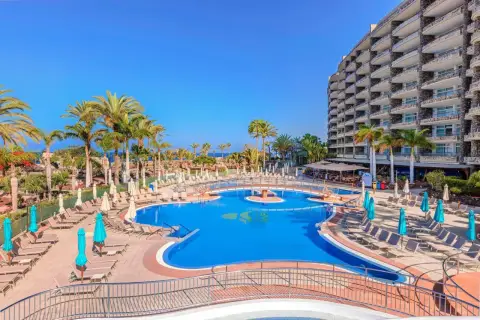 Luksusowy hotel z basenem i palmami, idealne miejsce na wakacje nad morzem. Anfi del Mar zaprasza!