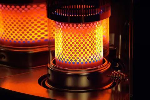 Estufa de parafina encendida, con llama naranja y azul. Considera sus pros y contras para calentar tu hogar.