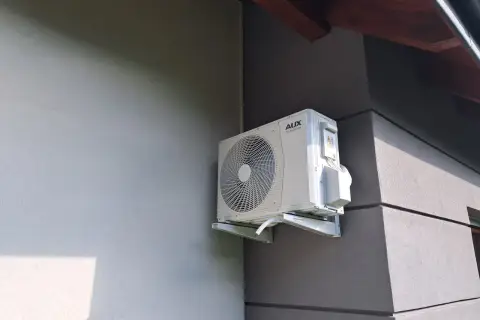 Zastanawiasz się, jaka klimatyzacja do domu będzie najlepsza? Zobacz, jak wygląda jednostka zewnętrzna klimatyzatora AUX DC INVERTER zamontowana na ścianie budynku.