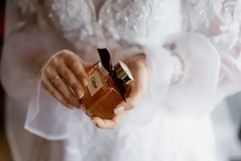 Dłonie trzymają buteleczkę perfum Chloé, idealną do ślubnego rankingu perfum damskich.