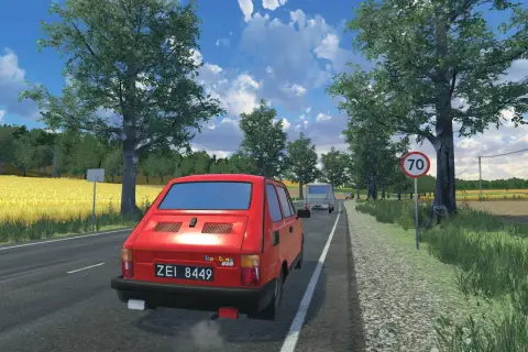 Czerwony Fiat 126p jedzie drogą w letni dzień. To widok z gry, gdzie można poczuć klimat podróży.