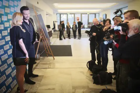 Sylwia Juszczuk z mężami pozuje do zdjęć, otoczona przez fotoreporterów.