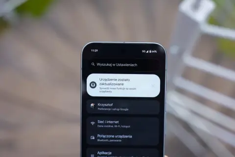Ekran telefonu z powiadomieniem o aktualizacji systemu. Widoczne ikony sieci 5G i baterii, a także menu Ustawień z opcjami Sieć i internet, Połączone urządzenia i Aplikacje, typowe dla systemu android 16.