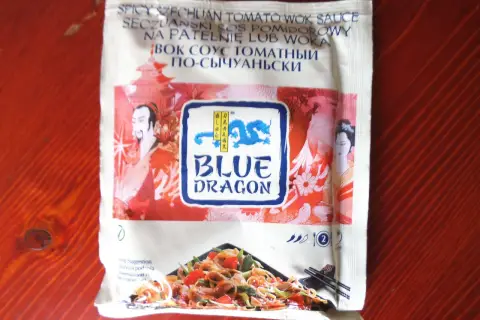 Sos seczuański Blue Dragon z pomidorami, idealny do dań z woka. Na opakowaniu smok i postacie z Azji.