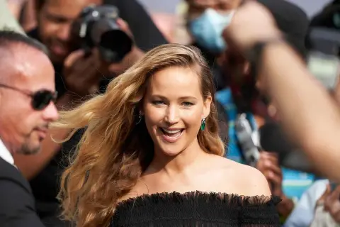 Jennifer Lawrence, uśmiechnięta, otoczona przez paparazzi. Ciekawe, ile lat ma Jennifer Lawrence, gdy robi taką karierę?