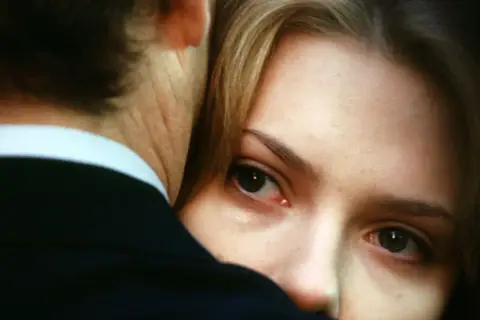 Un primo piano intenso di Charlotte, con un occhio lucido, abbracciata a Bob. La trama di Lost in Translation cattura la solitudine e la connessione inaspettata.