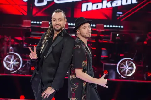 Tomson i Baron, dwaj charyzmatyczni artyści, pozują plecami do siebie na scenie "The Voice of Poland".