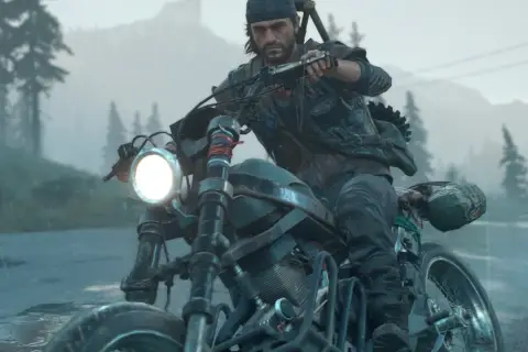 Mężczyzna w czapce i kamizelce jedzie motocyklem w deszczu, w tle las i góry. To scena z gry Days Gone 2.