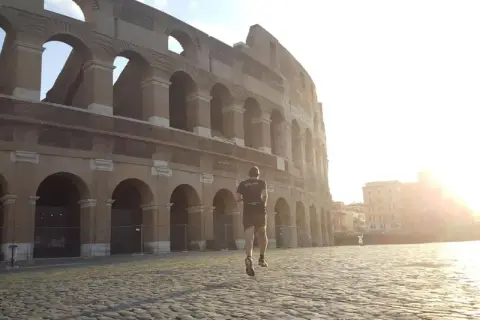 Un coureur matinal devant le Colisée, une image parfaite pour un séjour à visiter Rome en 3 jours.