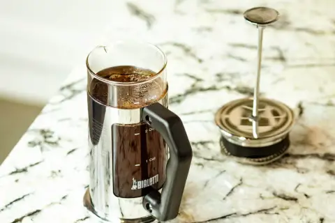 Elegancka kawiarka Bialetti z zaparzoną kawą po francusku. Gotowa do delektowania się aromatycznym napojem.