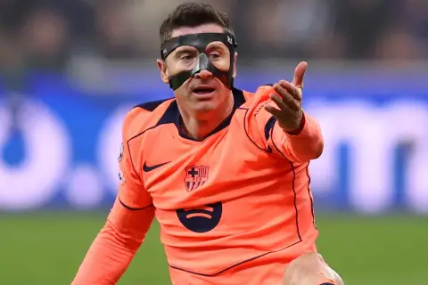 Robert Lewandowski w masce ochronnej na twarzy, wyjaśniając dlaczego lewandowski gra w masce, podczas meczu.