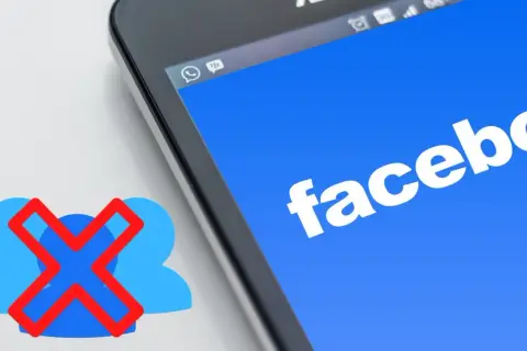 Chcesz wiedzieć, jak usunąć grupę na FB? Ikona z przekreślonymi ludzikami obok ekranu telefonu z logo Facebooka sugeruje rozwiązanie.