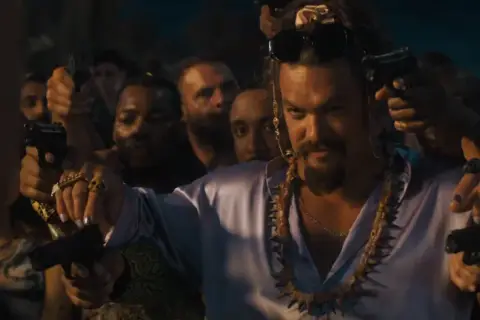 Jason Momoa z pistoletami w tłumie, jako nowy złoczyńca w obsadzie Szybcy i wściekli 10.