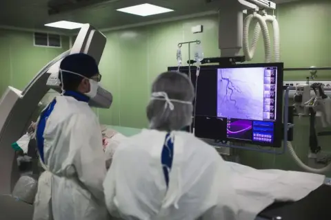 Lekarze analizują obraz z koronarografii na monitorze, oceniając stan naczyń wieńcowych.