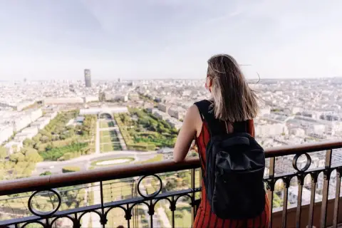 Kobieta z plecakiem podziwia panoramę Paryża. To idealny czwartek po francusku, pełen słońca i widoków.