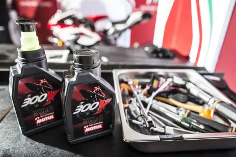Dwie butelki oleju Motul 300V obok narzędzi. Czy Motul jest lepszy do motocykli sportowych?