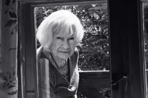 Portret starszej kobiety z siwymi włosami, patrzącej przez okno. Może to być inspiracja do filmów Doroty Kędzierzawskiej.