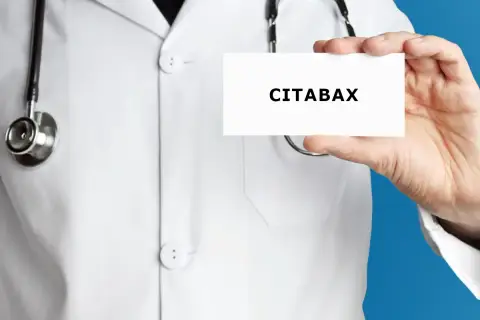 Lekarz w białym kitlu prezentuje wizytówkę z napisem CITABAX. Czy to lek na stres?