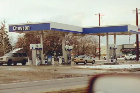 Stacja Chevron, samochody na zimowym parkingu. Zastanawiasz się, ile kosztuje jeden galon benzyny w USA?