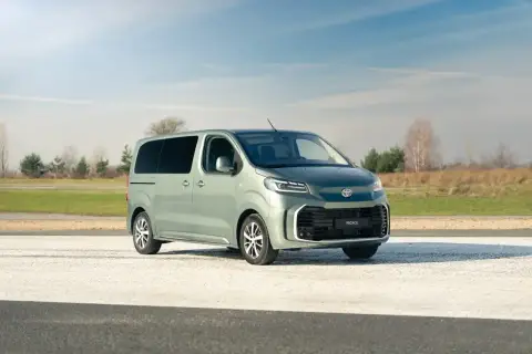 Nowy, zielony Toyota Proace na tle nieba i pól. Idealny do rodzinnych podróży i transportu.