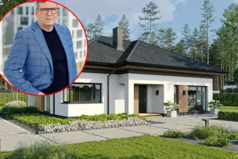 Mężczyzna w garniturze obok nowoczesnego domu. Szacowany koszt budowy domu 220m2.