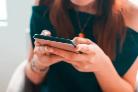 Kobieta pisze na telefonie, planując zakupy na Vinted z opcją PayPo.