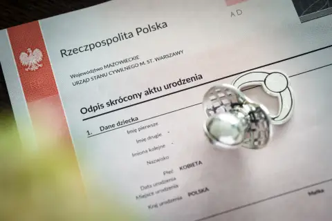 Odpis aktu urodzenia z Polski, obok smoczek. Dokument zawiera dane dziecka, w tym miejsce na wpisanie imion, które mogą być jednymi z najpopularniejszych imion.