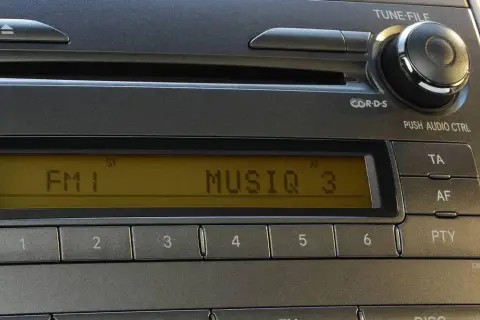 Radio samochodowe z wyświetlaczem RDS, pokazującym "FM 1 MUSIQ 3". Przyciski numeryczne i sterowanie.