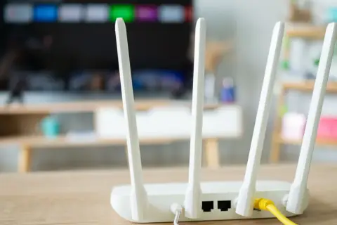 Router z antenkami, kluczowy element instalacji internetowej w domu. Zapewnia łączność dla telewizora i innych urządzeń.