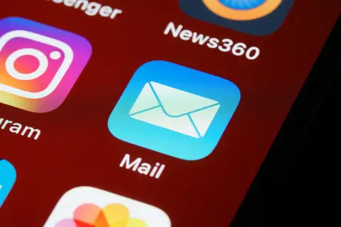 Ikona aplikacji Mail na ekranie telefonu. Zastanawiasz się, jak zakończyć maila? Otwórz aplikację i zacznij pisać!