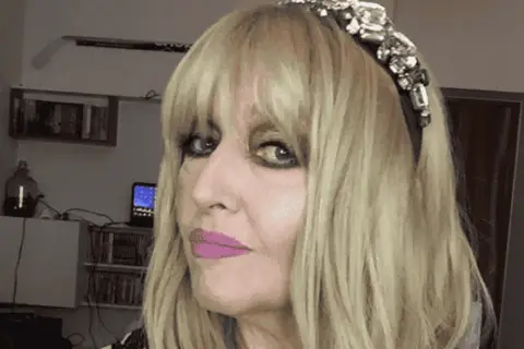 Portret Maryli Rodowicz z blond włosami, w opasce z cyrkoniami i różową szminką.