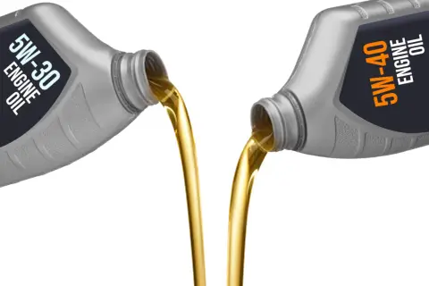 Aceite 5w30 vs 5w40: dos botellas vierten aceite dorado, mostrando la diferencia de viscosidad.