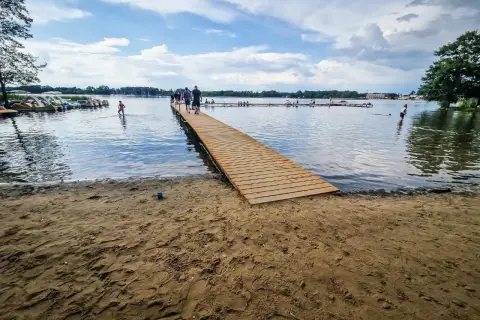 Drewniane molo i plaża nad jeziorem, gdzie można wypożyczyć rowerki wodne. To jedne z wielu atrakcji w Boszkowie.
